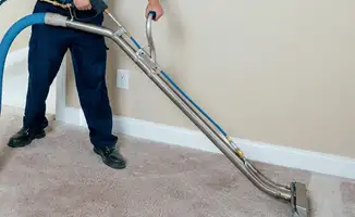 Professional operating a liquid removal machine on a carpeted floor in Anchorage, AK